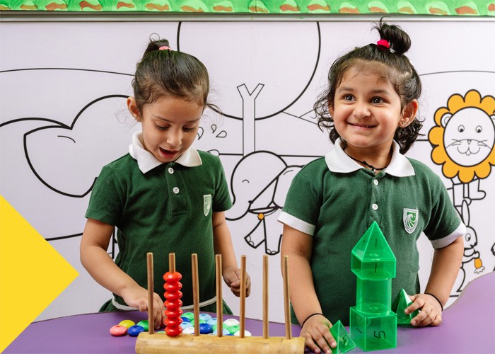 TGAA school students playing with shapes and an abacus.