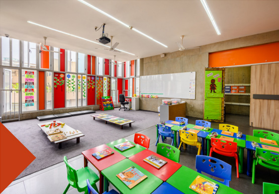The Green Acres Academy School classroom with colorful chairs and tables.