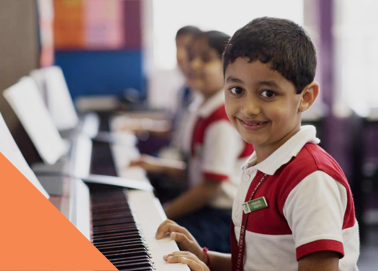 Students of The Green Acres Academy (TGAA) school in Mumbai playing piano.
