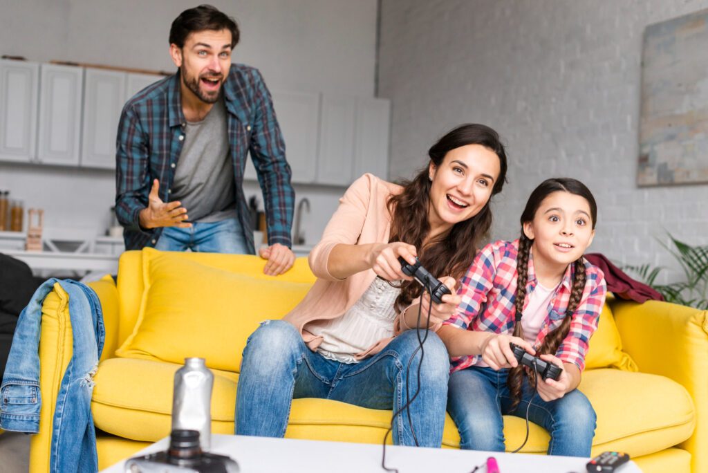A family (mother, father, and daughter) having fun and playing video games.